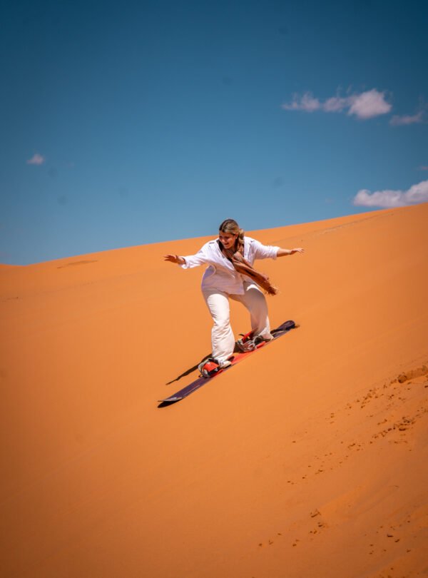 students sandboarding at the sahra desert